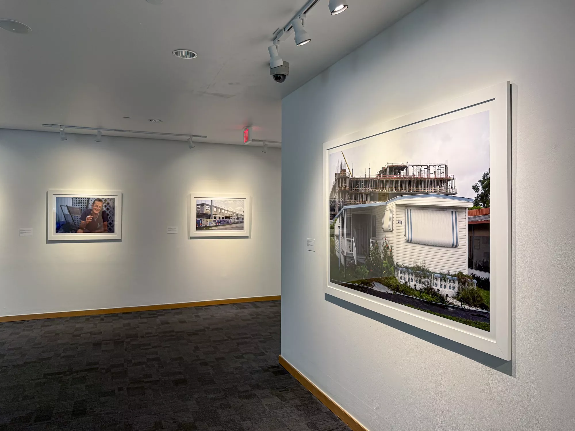 “Grow” (2021), part of Sunset Colonies, depicts a rising construction project looming in the background of a mid-century mobile home. Artwork by Diego Waisman/ Photo by William Riera.